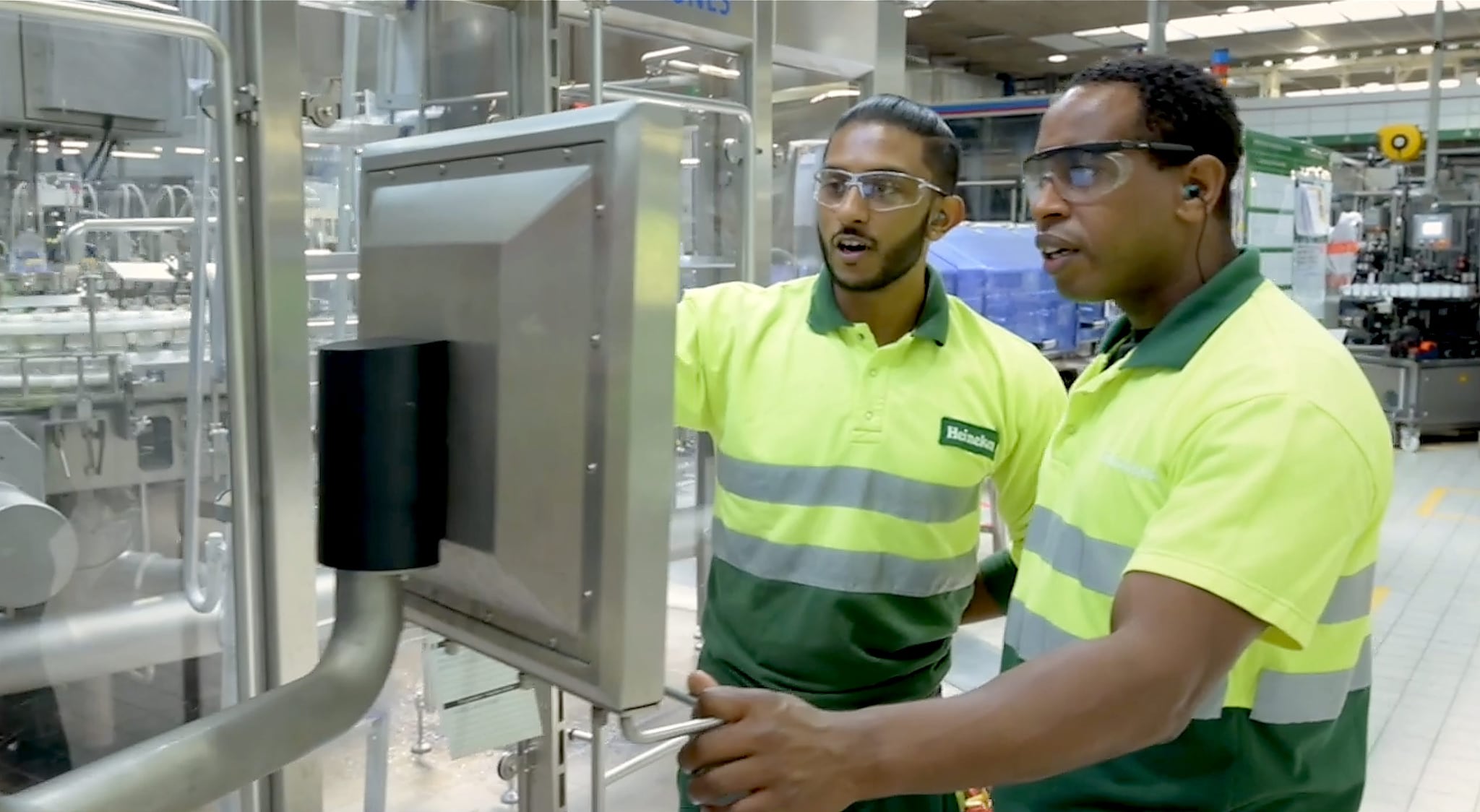 Heineken employees consult technology that monitors the brewing process